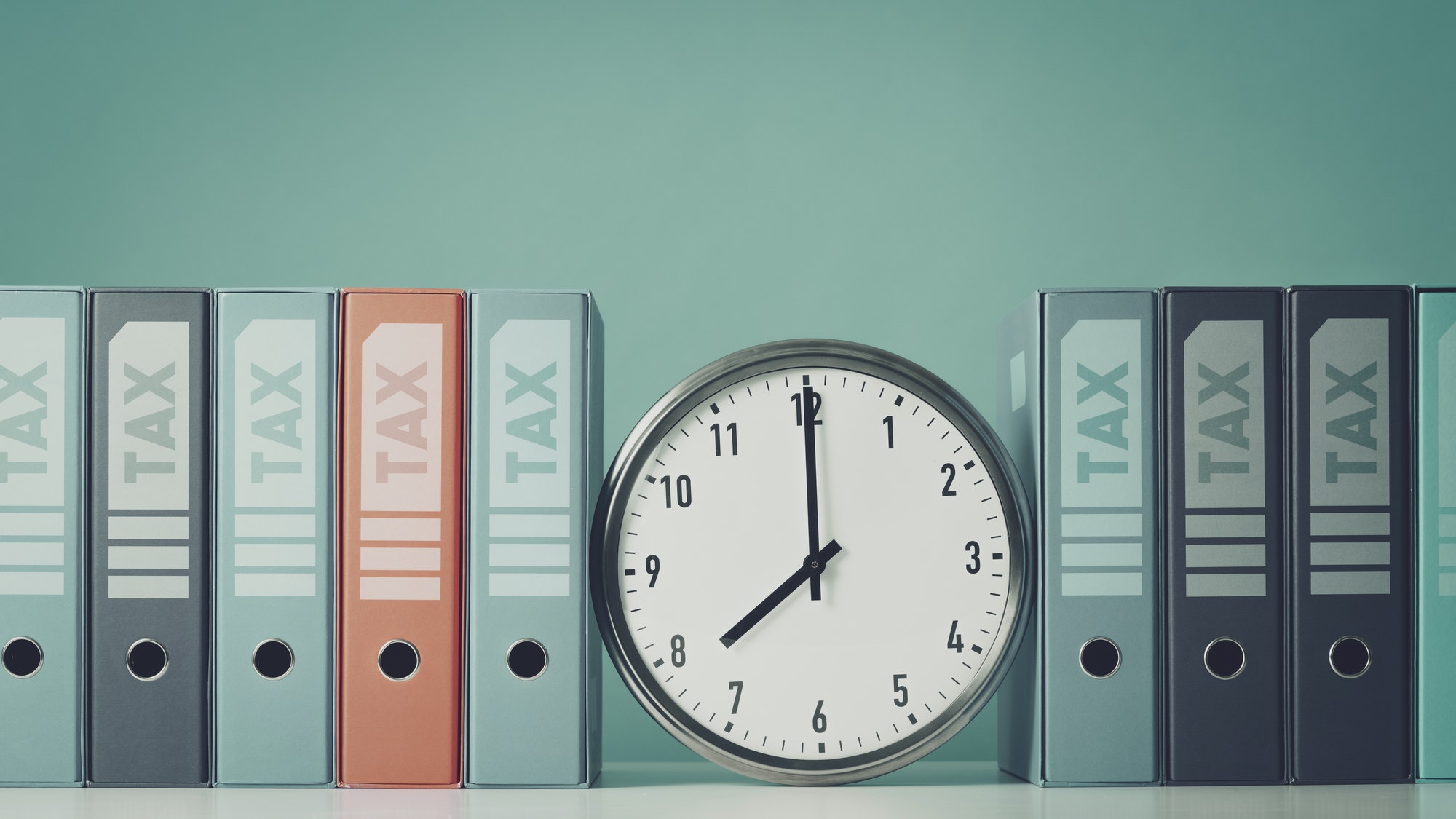 Ring binders containing tax documents and clock